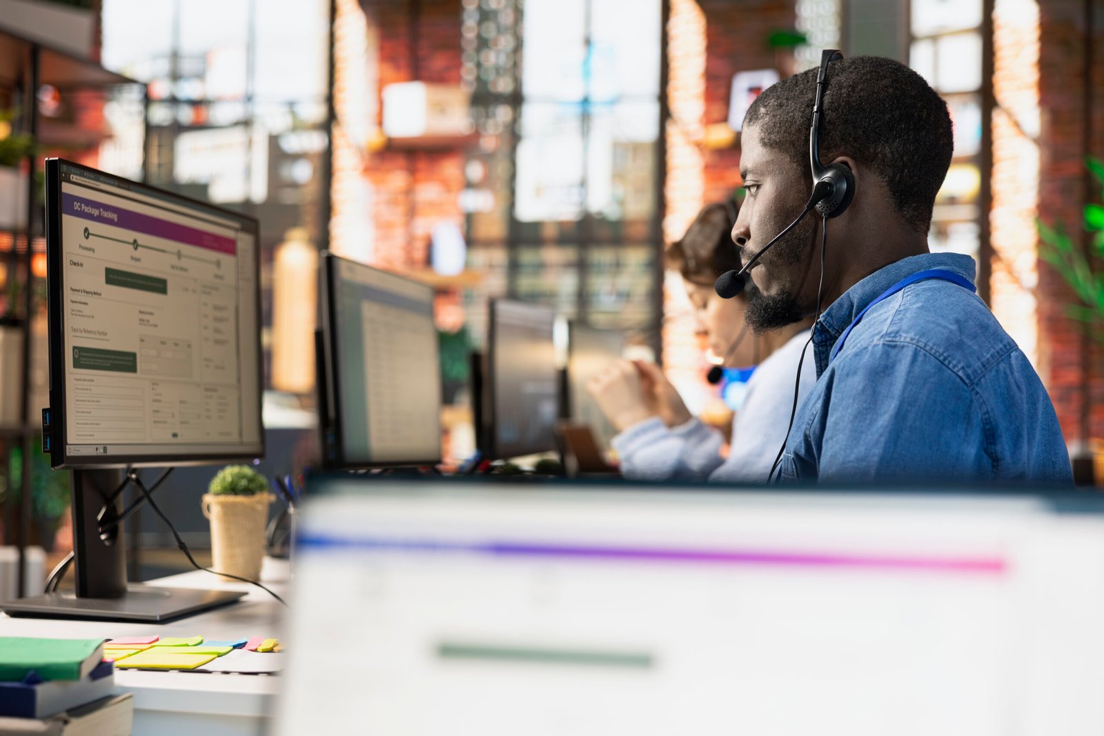 Call center agent tracking shipments in office, looking at PC screen, handling delivery delays. Customer center employee using software to locate clients packages and provide status updates